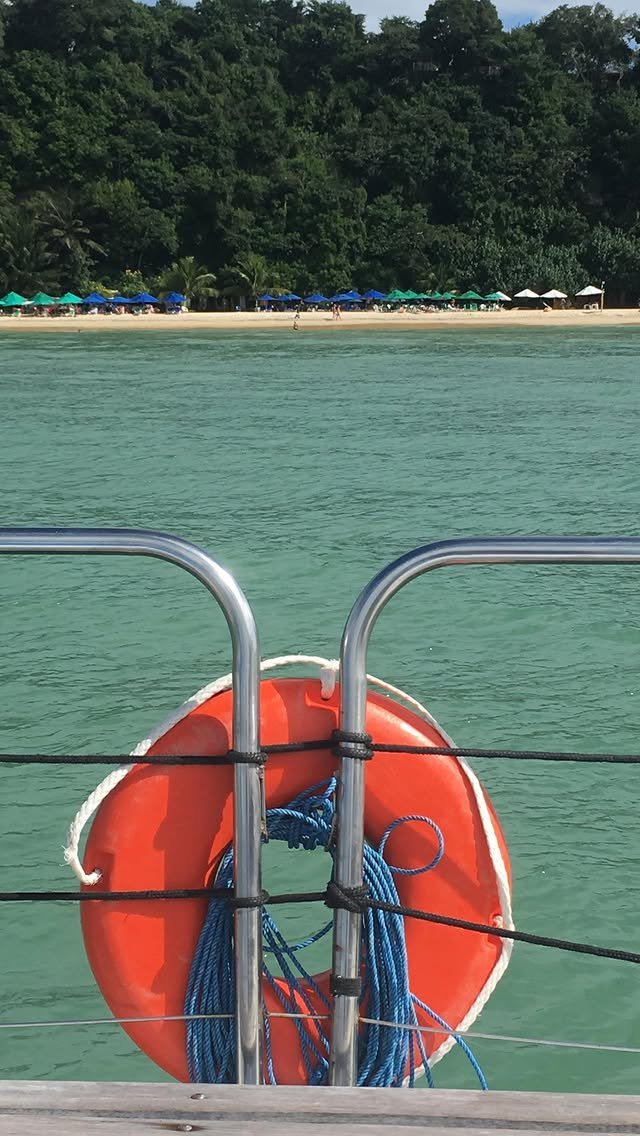 Boia salva-vidas a bordo, com a praia ao fundo